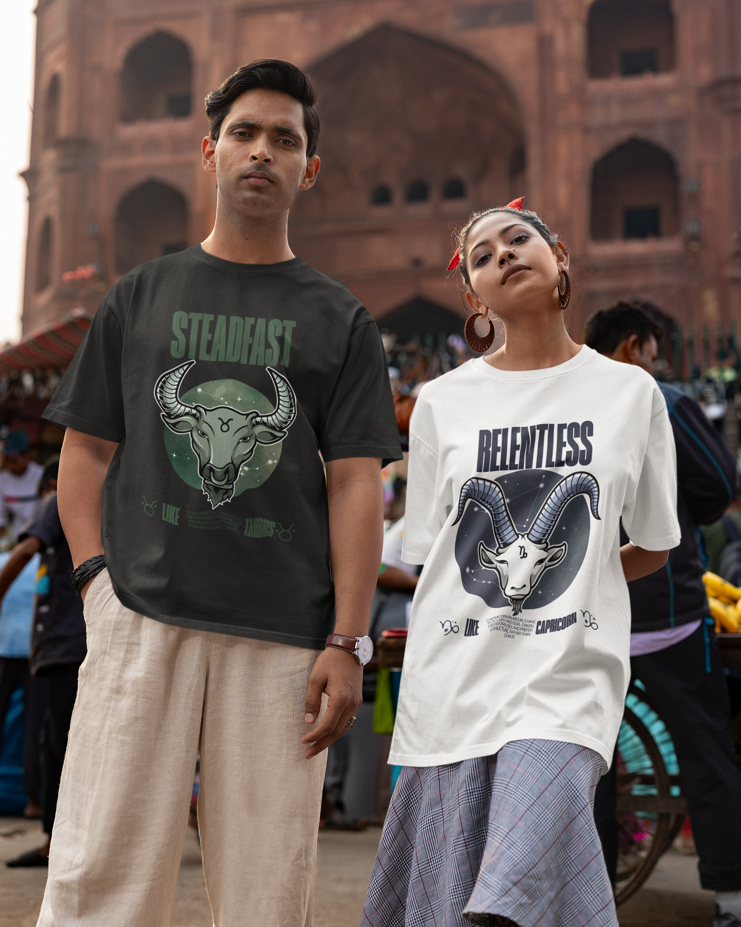 Two people wearing t-shirts with graphic designs in front of a historic building.