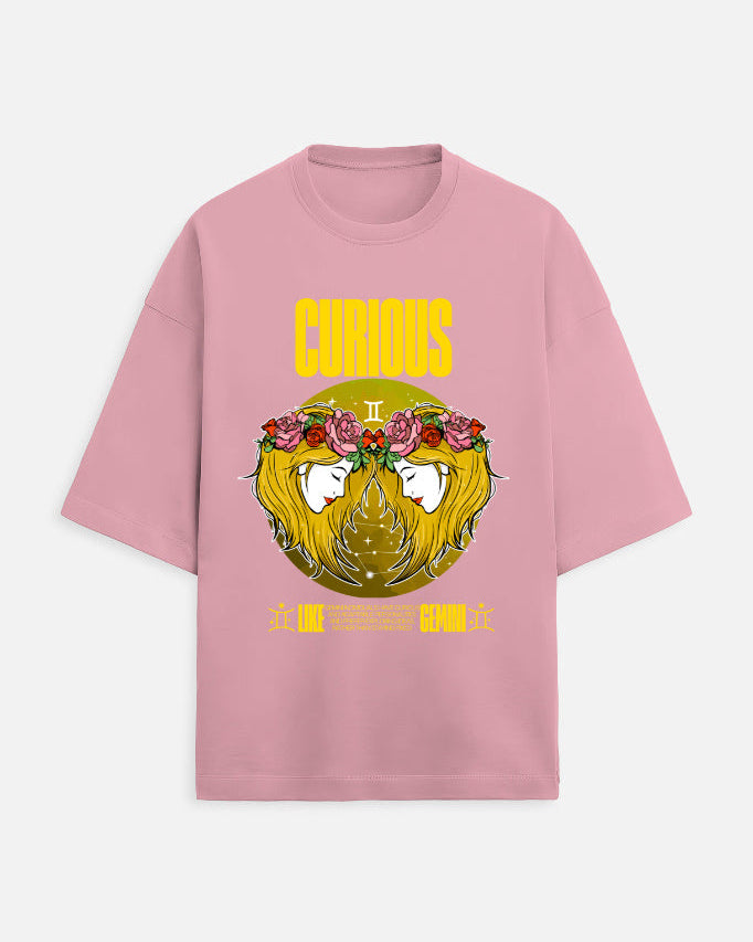 Pink t-shirt with a graphic design of a face with flowers and the word 'Curious' on a white background.
