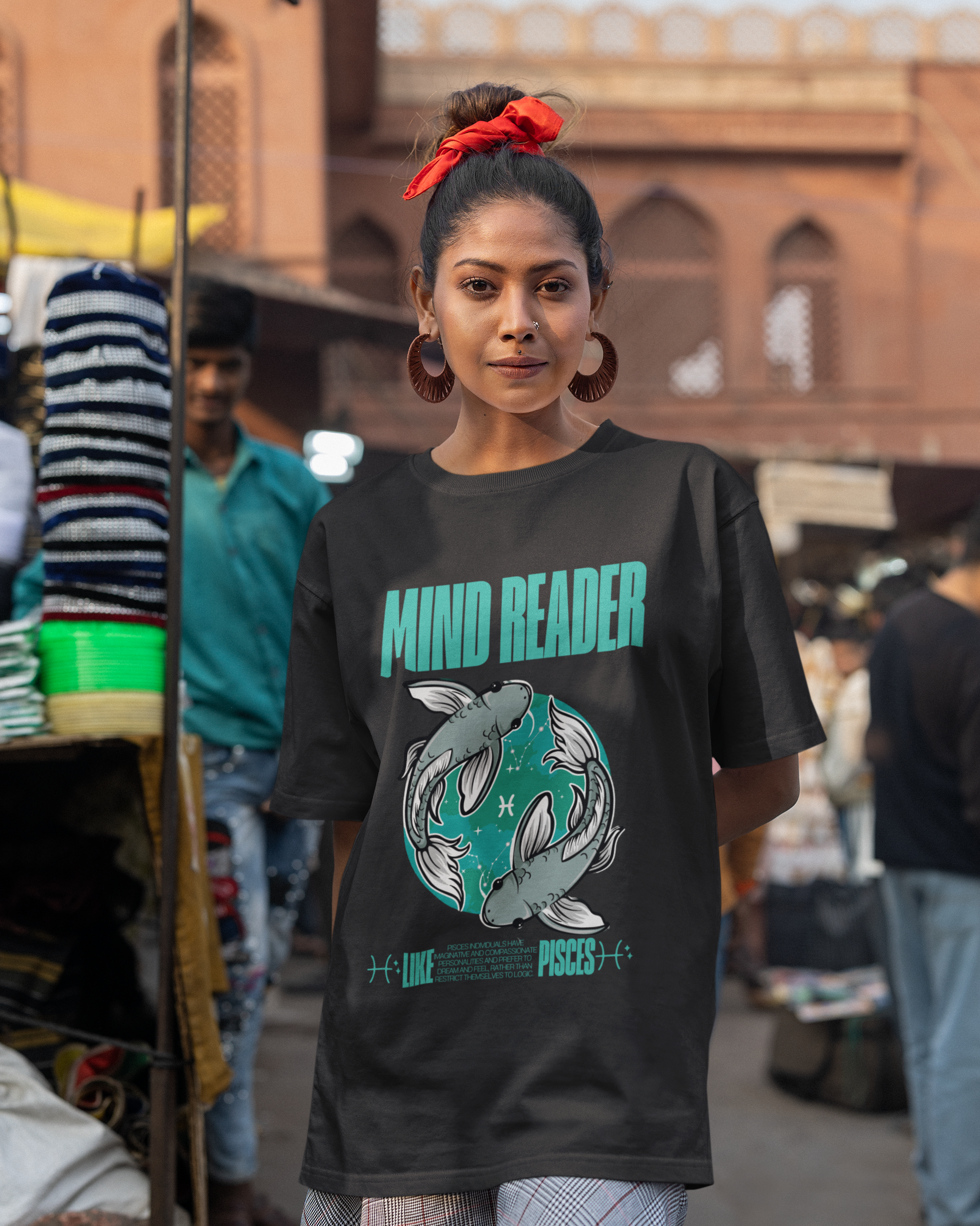 Woman wearing a black t-shirt with 'Mind Reader' graphic in a market setting