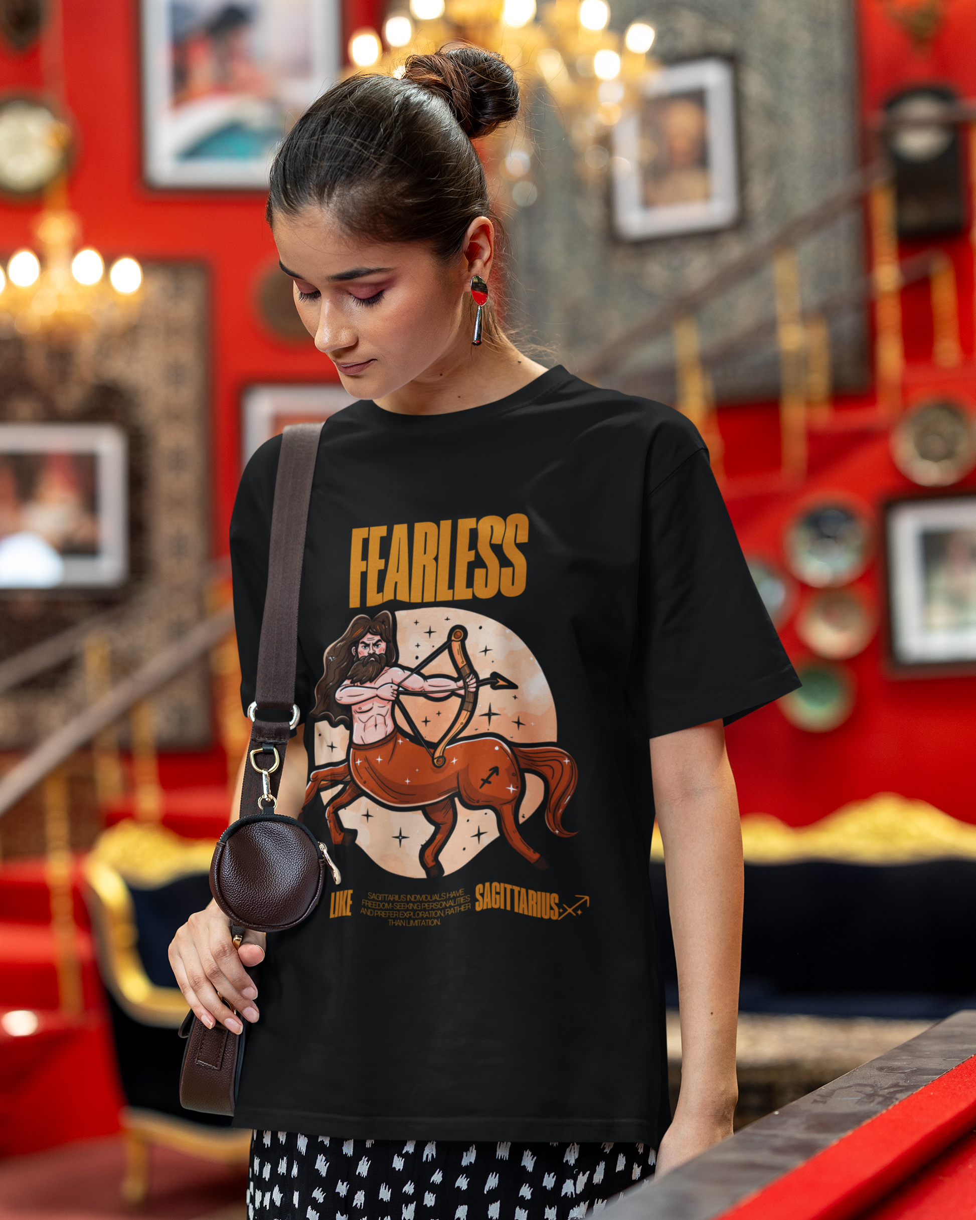 Woman wearing a black t-shirt with 'Fearless' and horse graphic, standing in a decorated room.